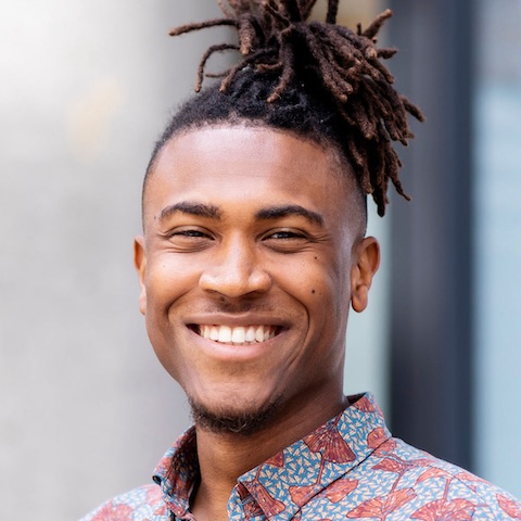 Heldiney smiling while wearing a colourful shirt.